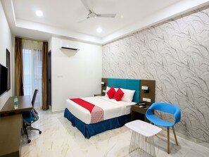 A hotel room with a bed, a desk, a chair, and a TV. - OYO 13219 Sri Rama Excellency (Hyderabad)