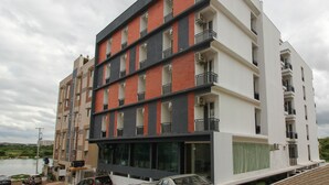 A multi-story residential building with balconies, large windows, and a flat roof.