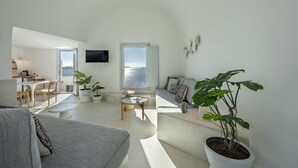 A modern living room with a sofa, coffee table, and potted plants. - Big Blue Villa by Caldera Houses (Santorini)
