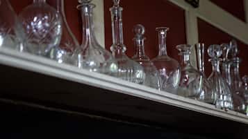 Varias botellas de vidrio transparente sobre una estantería.