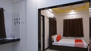 Ein Schlafzimmer mit einem Bett, einem Nachttisch, einem Spiegel und einer Duschgelegenheit.