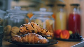 Een ontbijttafel met croissants en een schaal fruit.