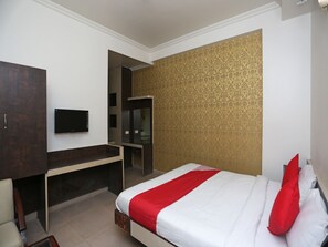 A hotel room with a bed, a desk, a wardrobe, and a television. - OYO 19334 Flagship Shanta Inn Charbagh (Lucknow)