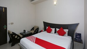 A hotel room with a bed, a desk, and a chair. - OYO 19334 Flagship Shanta Inn Charbagh (Lucknow)