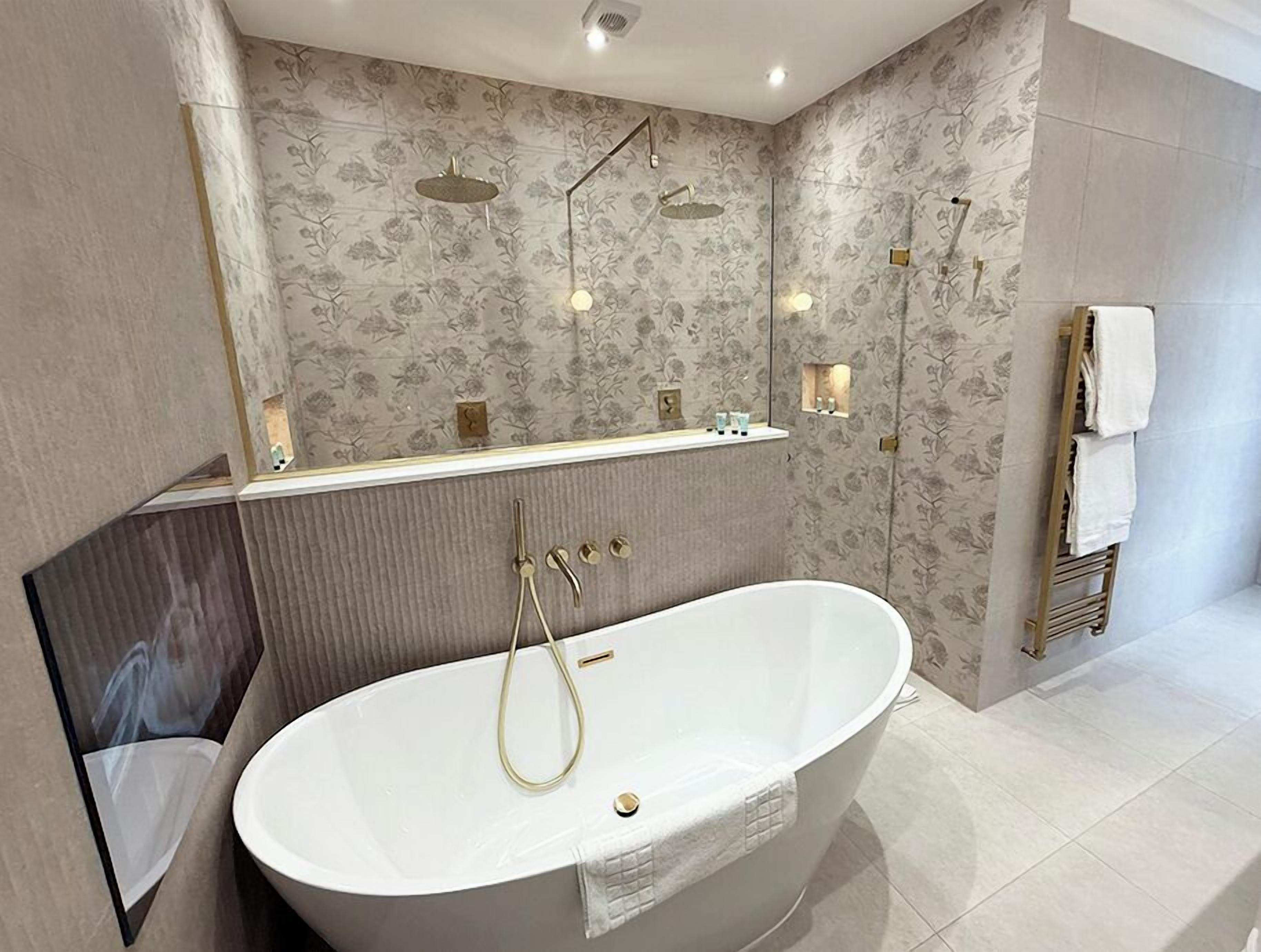 Un baño moderno con una bañera independiente, un tocador con espejo y un perchero para toallas.