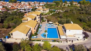 Un resort con varias construcciones, una piscina y vista al mar.