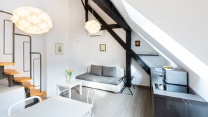 Een modern loft appartement met een eethoek, een bank en een kitchenette.