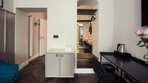 Een moderne keuken met een centraal eiland, een eethoek met een zwarte stoel en een kleine tafel met een koffiezetapparaat.