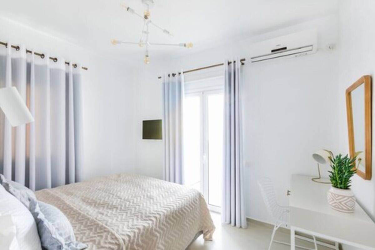 A modern bedroom with a bed, a desk, and a chair.