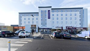 Ett hotell med en genomfartsväg för bilar, gott om parkeringsplatser och ett övergångsställe för fotgängare.