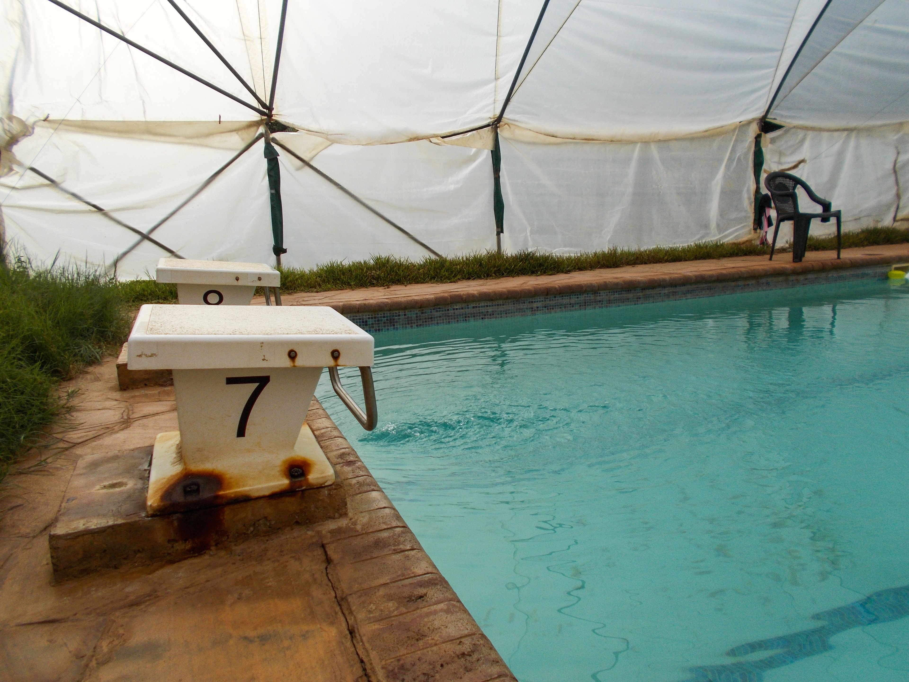 A swimming pool with a lifeguard chair and a number 7 sign.