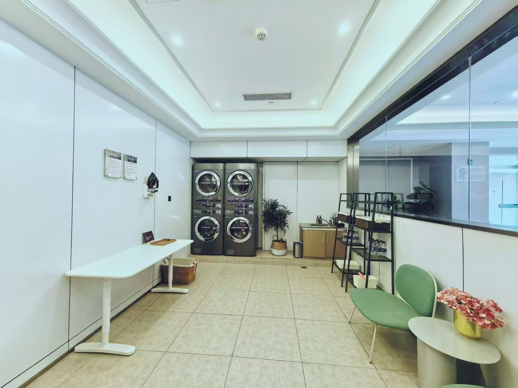 A modern hotel lobby with a reception desk, seating area, and a large window.