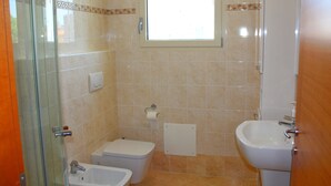 Une salle de bain équipée de toilettes, d’un bidet et d’un lavabo.