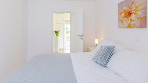 A bedroom with a bed, a nightstand, a lamp, and a painting on the wall. - Color Apartments (Zupa dubrovacka)