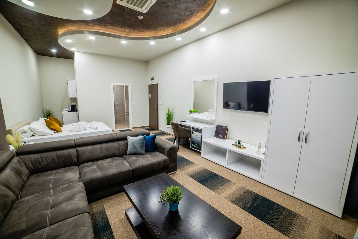 A modern waiting area with a sofa, a coffee table, a desk, and a cabinet.