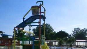 Un patio de recreo con un tobogán y estructuras para escalar.
