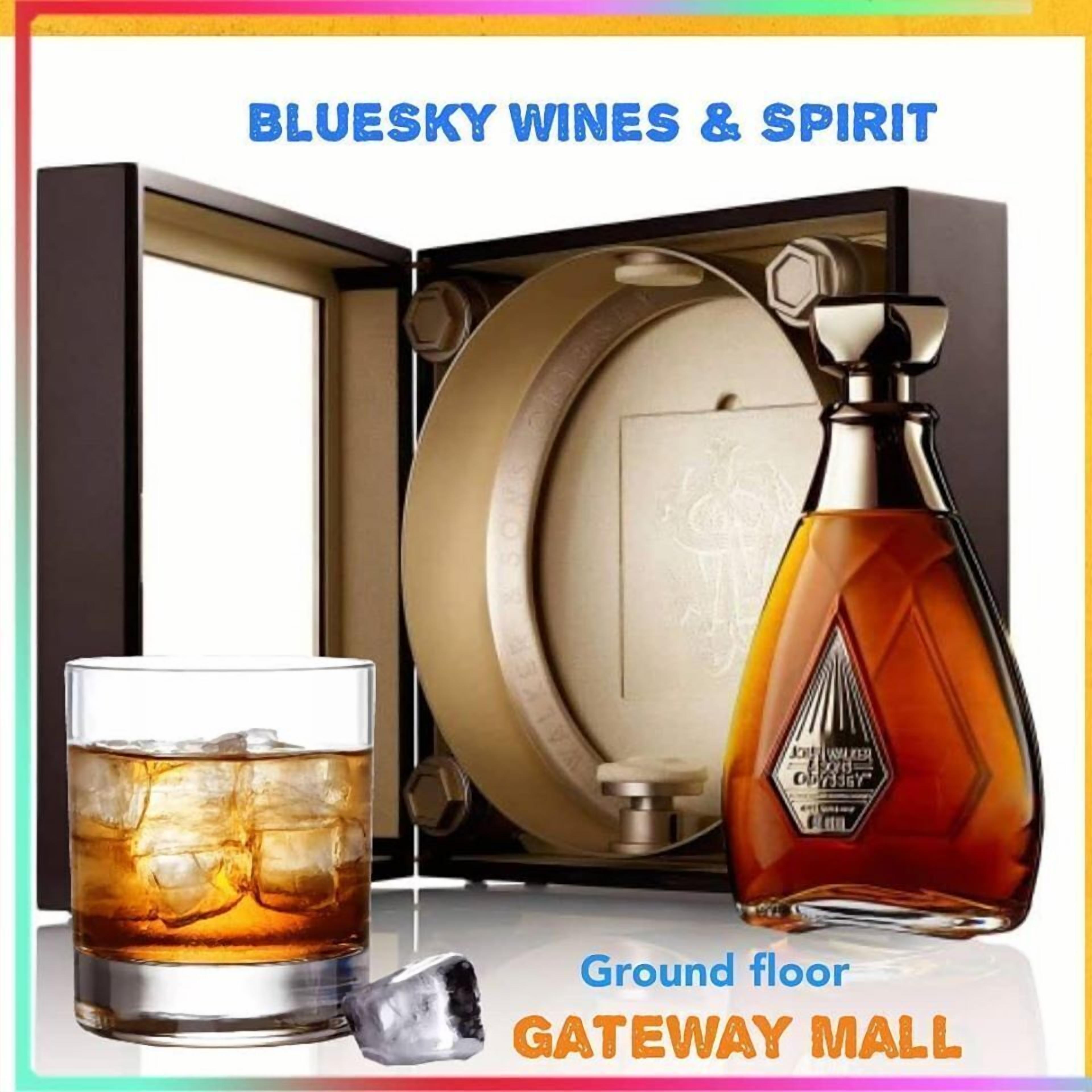 Eine Whiskeyflasche und ein Glas mit Eis auf einem Tisch, dazu eine Whiskeyflasche und ein Glas in einer Kiste.