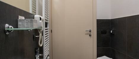 A modern bathroom with a curved sink, bidet, and a toilet.