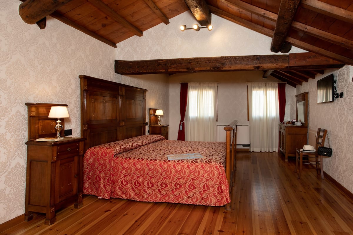A bedroom with a wooden bed, a nightstand, a dresser, and a mirror.