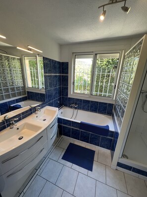 Baignoire, séchoir à cheveux, papier de toilette