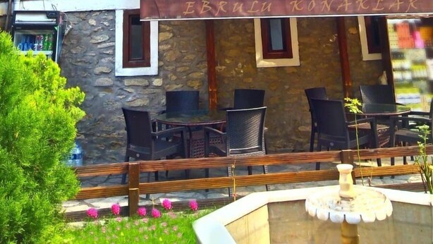 A multi-story building with wooden balconies and a restaurant area with outdoor seating.