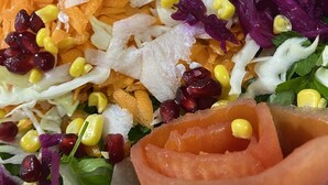 A colorful salad with various vegetables and corn.