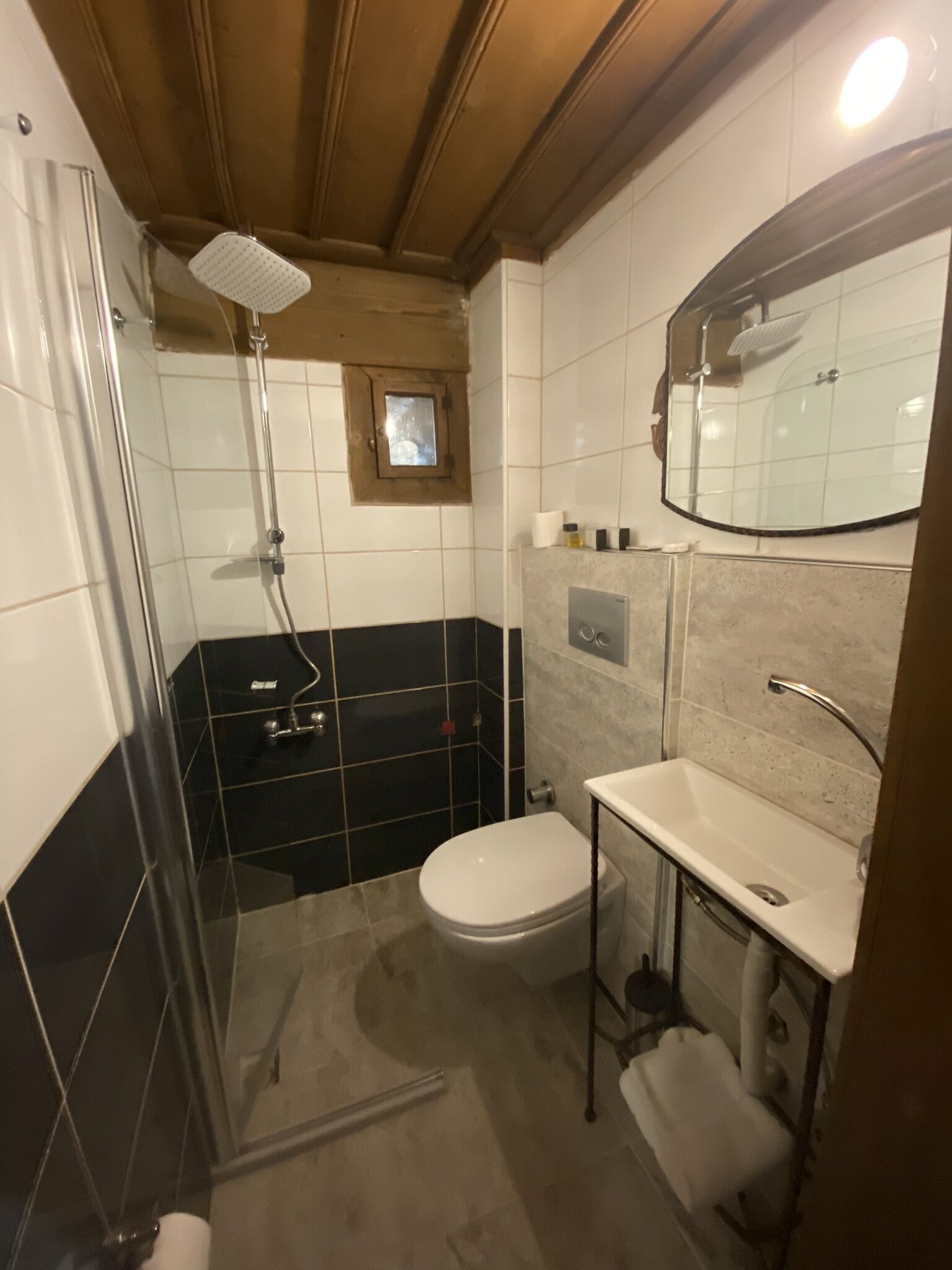 Ein Badezimmer mit Dusche, Toilette, Waschbecken und Spiegel.