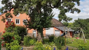 A house with a garden, a swing set, and a fence. - Eifel Dream Landhaus (Plütscheid)