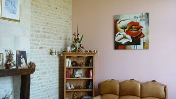 A living room with a brick wall, a bookshelf, a sofa, and a chandelier.