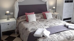A bedroom with a bed, a nightstand, a dresser, and a checkered floor. - Onda su Onda (La Spezia)