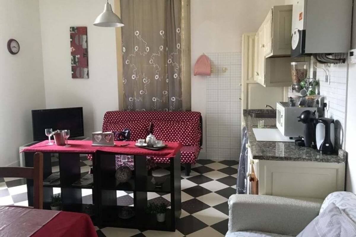 A compact living space with a dining area, kitchenette, and a sofa.