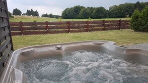 A hot tub with a wooden fence and a grassy field in the background. - Eifel Dream Zingsheld (Fleringen)
