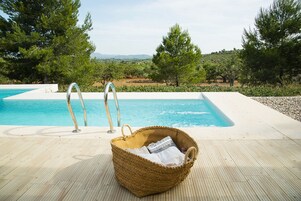 Una piscina al aire libre de temporada, sombrillas
