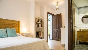Un dormitorio con una cama grande, una mesita de noche y una estantería.