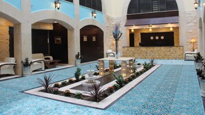 A spacious lobby with a fountain, seating areas, and a patterned floor. - Saray Hotel (Amman)
