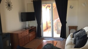 A bedroom with a bed, a TV, a ceiling fan, and a sliding glass door leading to a balcony. - Penthouse Spacious  2 Bedroom Apartment with massive balcony in lovely Town (Xylofagou)
