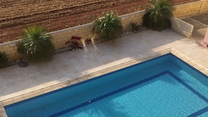 A rectangular swimming pool with clear blue water, surrounded by a tiled deck. - Penthouse Spacious  2 Bedroom Apartment with massive balcony in lovely Town (Xylofagou)