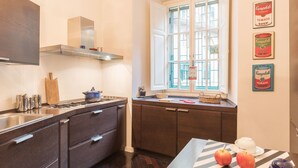 Une cuisine moderne avec des meubles de couleur sombre, un évier en acier inoxydable et une fenêtre offrant une belle vue.