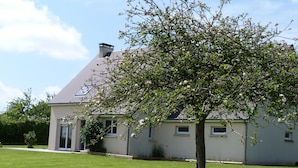 A house with a sloped roof, a well-maintained lawn, and a tree in the foreground. - HOUSE WITH SEA VIEW ON NICE PLOT (Crasville)
