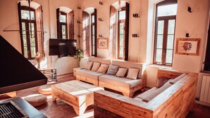 Een gezellige woonkamer met een houten bank, een salontafel en een televisie.
