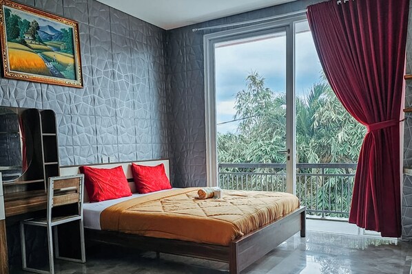 Une chambre avec un lit, une télévision, un tableau et un balcon donnant sur un paysage verdoyant.