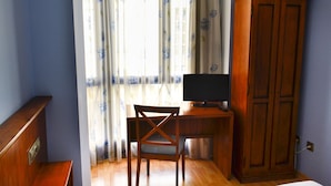 A room with a wooden desk, a chair, a television, and a wardrobe. - Alda Vía de la Plata Rooms (La Baneza)