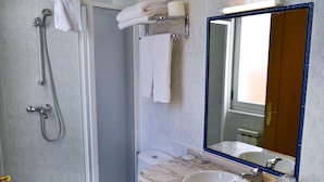 A bathroom with a marble sink, a large mirror, a shower with a handheld showerhead, and a toilet. - Alda Vía de la Plata Rooms (La Baneza)