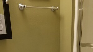 Kylpyhuoneessa on valkoinen pesuallas, musta allaskaappi, valkoinen wc-istuin ja pyyheteline.