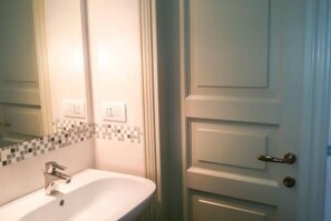 A bathroom with a white sink, a mirror, and a tiled backsplash. - Agriturismo Villalta (Perugia)