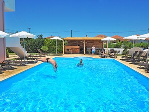 Una piscina al aire libre de temporada, sombrillas