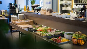 Ein Buffet mit verschiedenen Speisen und im Hintergrund eine Kaffeemaschine.
