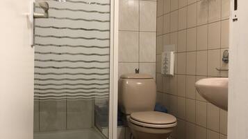Un baño con ducha, inodoro y lavabo.