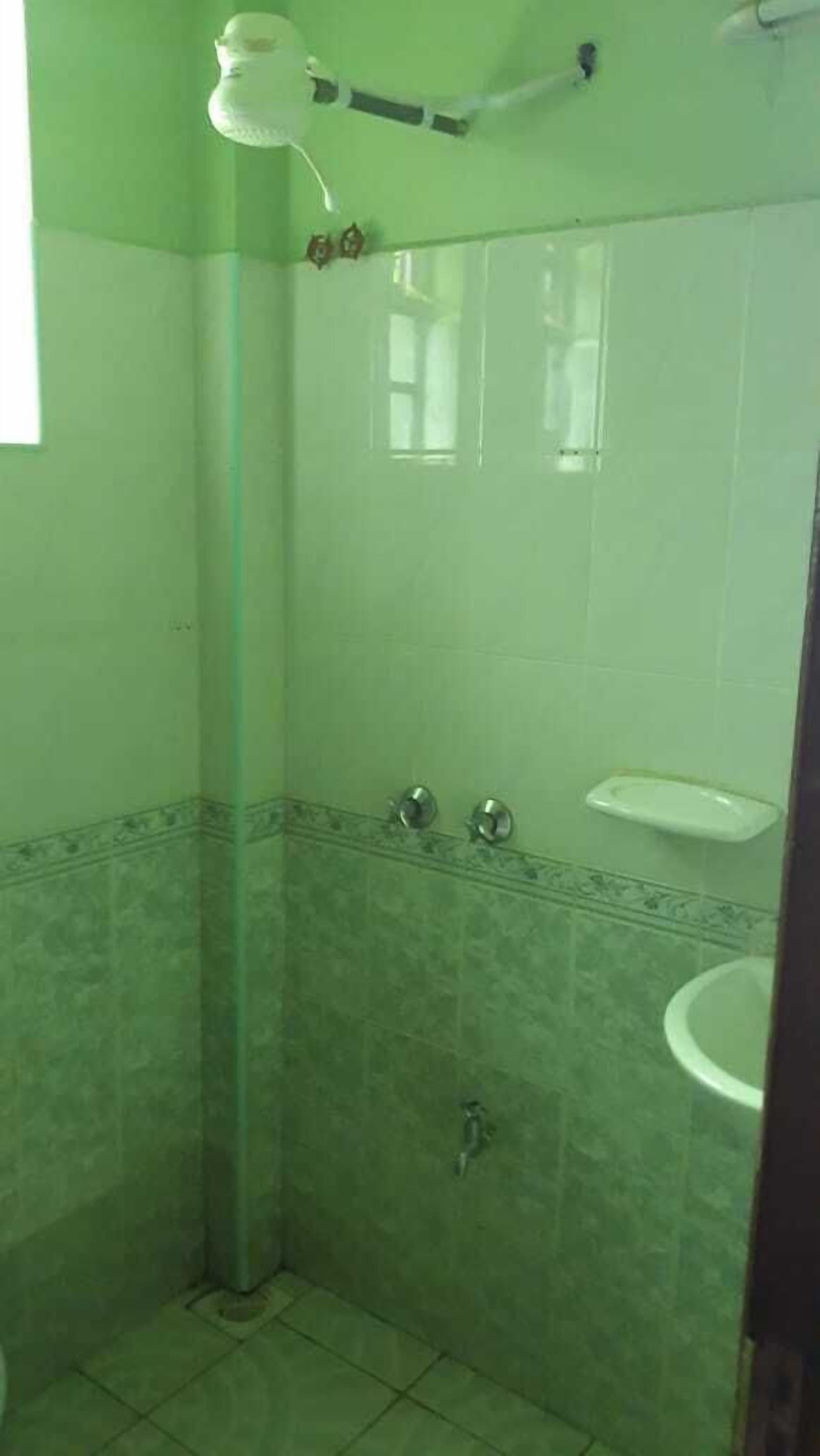 Une salle de bain avec une douche, des toilettes et un lavabo.