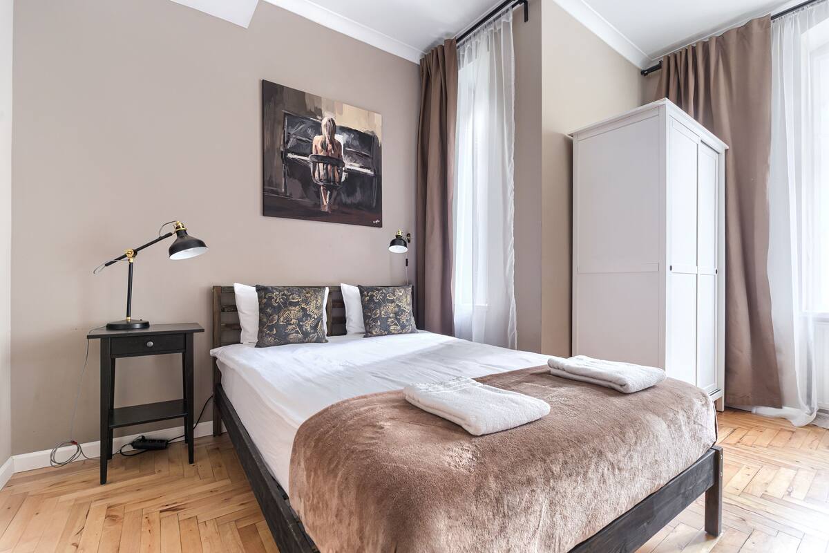 Un dormitorio con una cama, una mesita de noche, una lámpara, un armario y un cuadro en la pared.